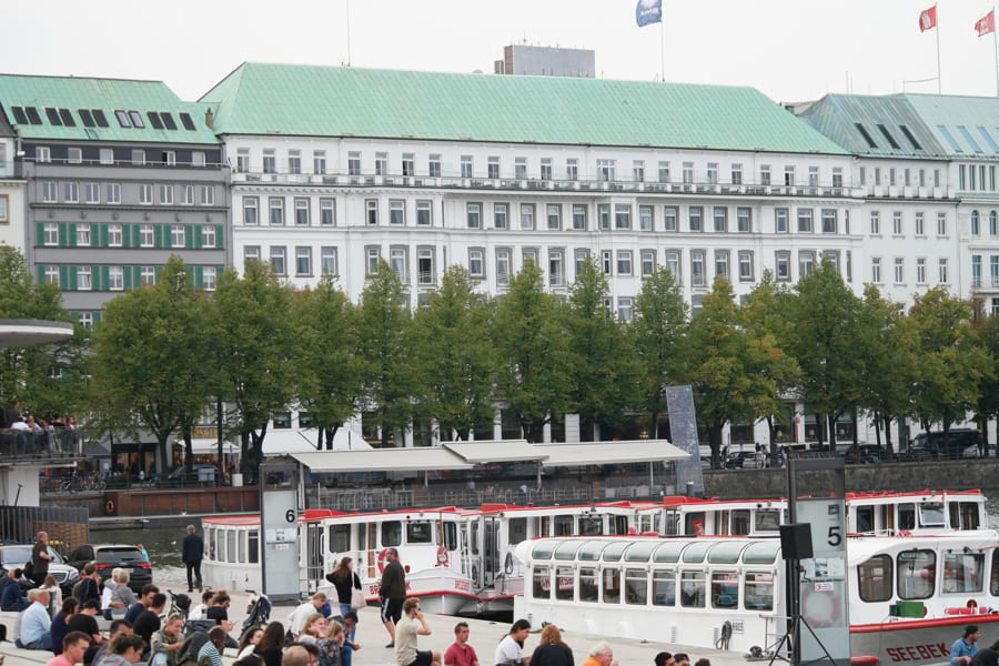 Das weiße 5-Sterne-Luxushotel Vier Jahreszeiten in Hamburg direkt an der Binnenalster mit Alsterschiffen davor