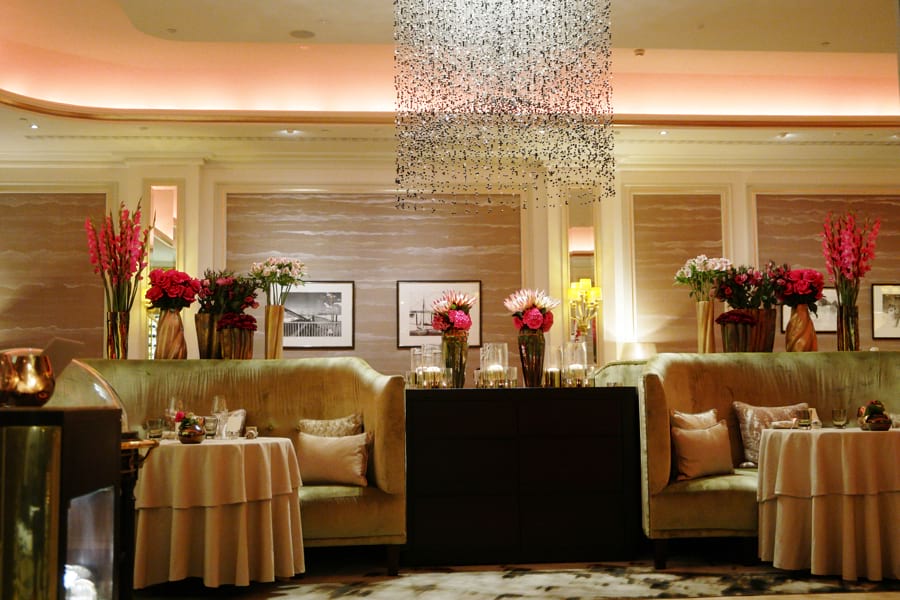 2-Sterne Restaurant Haerlin Interieur mit luxuriösen Sofas in hellem Grünton, crèmefarbenen Tischdecken und chinesischen Seidentapeten