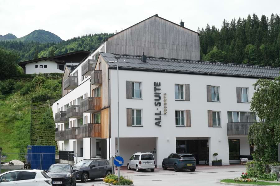 All-Suite Resort Fieberbrunn Außenansicht, weiße Fassade, Balkone aus Holz